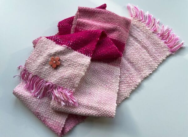 Kleine handgesponnen en handgeweven sjaal in roze en wit. Met alpaca, merinowol en sarizijde op een katoenen ketting.